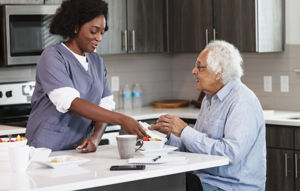 Caregiver preparing a meal with a senior in the kitchen
