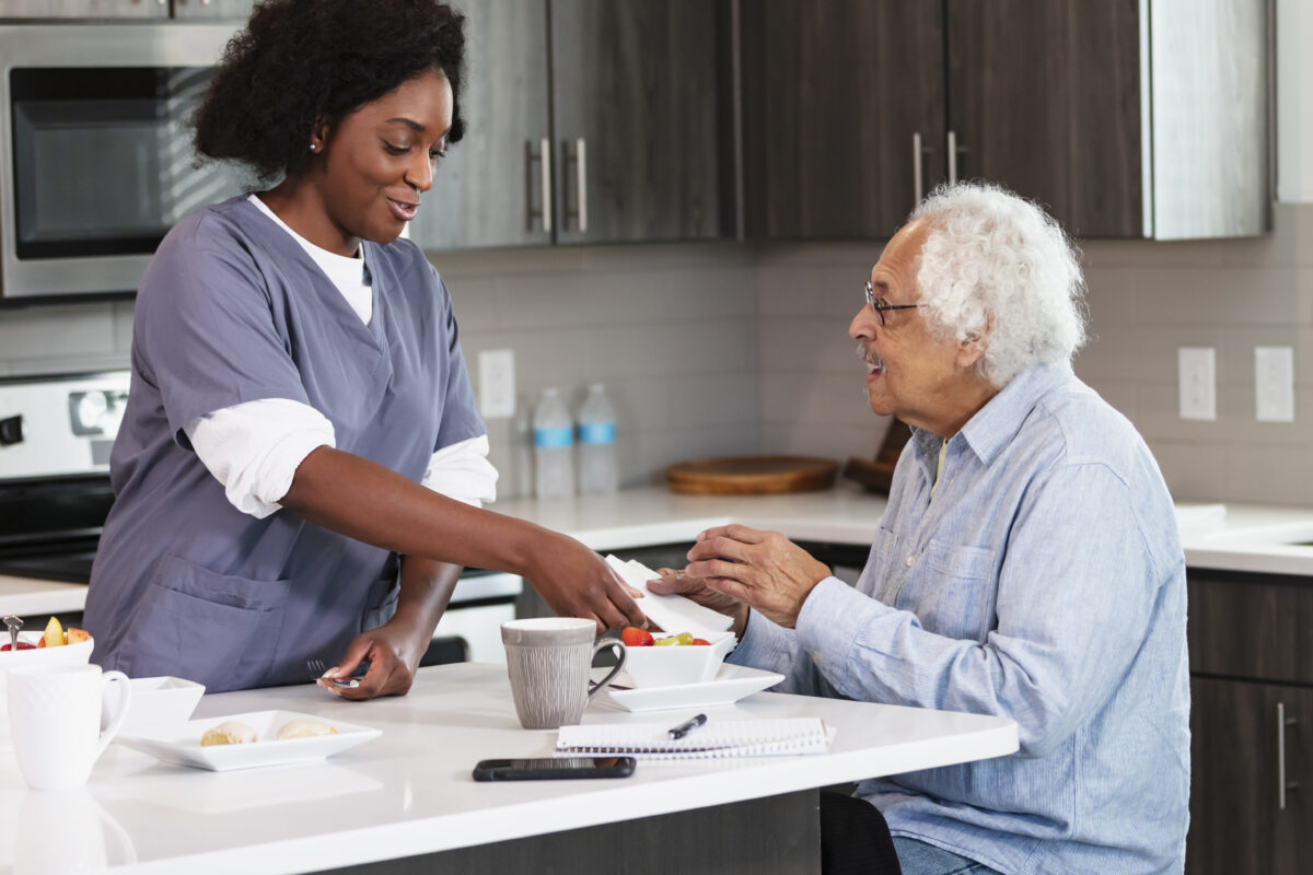 Caregiver preparing a meal with a senior in the kitchen